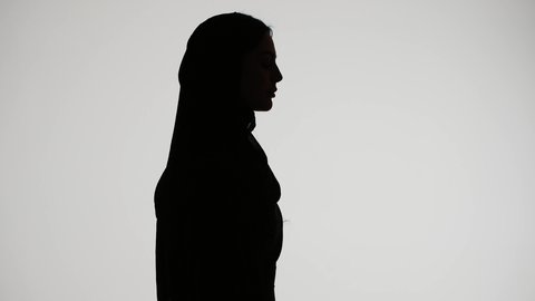 وسائل التواصل الإجتماعي ، إستخدام اجهزة تقنية حديثة ،  اجراء بث مباشر ،التقاط صور سيلفي تذكاريه بإستخدام الهاتف المحمول ، اجراء مكالمه هاتفيه ،تصوير ظلي لمرأة عربية خليجية اماراتيه ترتدي العباءه والحجاب ،خلفية بيضاء