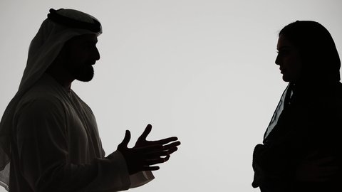 دفاع المرأة عن نفسها،  شجار بين الزوجين، ازمة في العلاقات الاسرية، مشاكل عائلية وصراع اسري، رجل إماراتي يرتدي الغترة والكندورة يقوم بضرب وتعنيف زوجته على وجهها، تصوير ظلي لزوجين عربيين خليجيين اماراتيين يتجادلان مع بعضهما بإيماءات الغضب، خلفية بيضاء