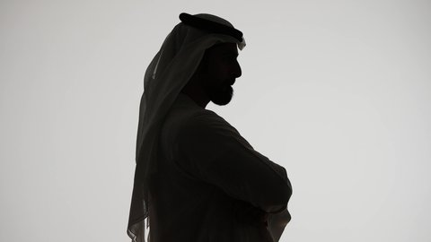 ايجاد حل لمشكلة ما،  التأمل والتخطيط للمستقبل، تصوير ظلي من الجانب لرجل عربي خليجي اماراتي يضع يده على ذقنه ينظر الى مكان ما بايماءات التفكير والتركيز، تعابير شرود الذهن والتمعن، خلفية بيضاء