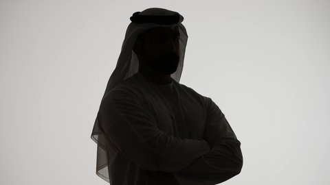 تعابير شرود الذهن والتمعن، ايجاد حل لمشكلة ما،  التأمل والتخطيط للمستقبل، تصوير ظلي من الجانب لرجل عربي خليجي اماراتي يضع يده على ذقنه ينظر الى مكان ما بايماءات التفكير والتركيز، خلفية بيضاء