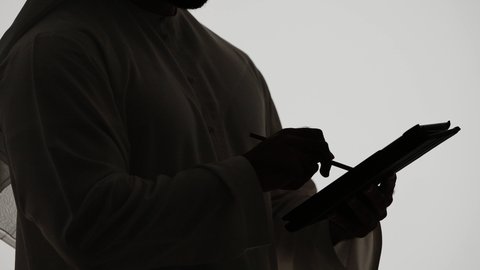 Emirati jobs and professions, online chat, online shopping using tablets, integrating modern technologies into daily life, communicating with family and friends, completing tasks remotely, silhouette of an Emirati Gulf Arab man holding a laptop, white background
