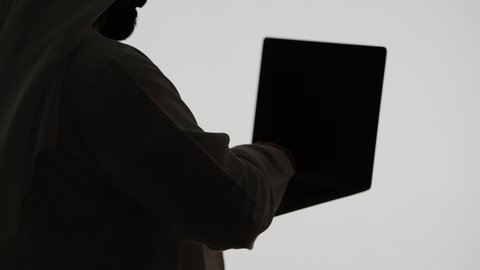 دمج التقنيات الحديثه فى الحياه اليوميه ، تصوير ظلي لرجل عربي خليجي اماراتي ، إستخدام جهاز الحاسوب المحمول ، تصفح مواقع التواصل الاجتماعي ، إستخدام اجهزة تكنولوجيا حديثة ، العمل عن بعد ، مفهوم التسويق الإلكتروني ، مهن ووظائف اماراتيه ، خلفية بيضاء