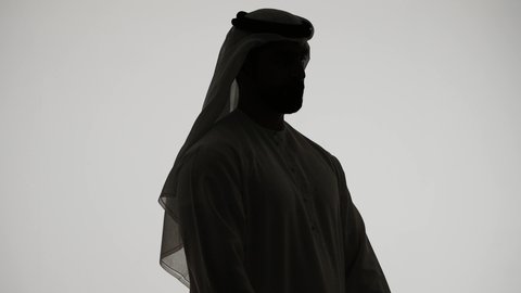 Seeing distant objects and bringing them closer, a love of exploration and adventure, a silhouette of an Arab Gulf Emirati man holding binoculars and looking at something with gestures of pleasure and enjoyment, white background