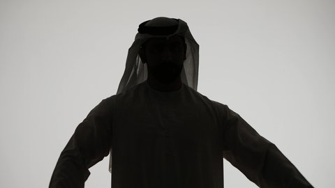 إستعراض القوة البدنية ،لياقة بدنية وصحة، تصوير ظلي لرجل عربي خليجي اماراتي ، يرفع يده بكفه مقبوضه ، القوة العضلية وعرض العضلات ، بناء جسم صحي ، خلفية بيضاء
