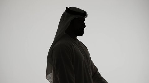 Recording a singing audio clip, presenting theatrical performances, enjoying the performance of vocal talents, silhouette of an Arab Gulf Emirati man holding a microphone, expressions of integration and interaction with music, white background