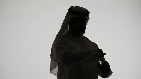 التخلص من سموم الجسم، المحافظة على سلامة الجهاز المناعي، أهمية شرب الماء النقي للمحافظة على بشرة نضرة، تصوير ظلي لرجل عربي خليجي اماراتي يقوب بشرب المياه من عبوة بلاستيكية، خلفية بيضاء