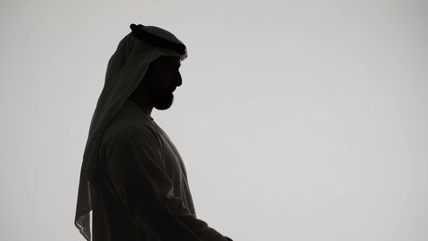 المحافظة على سلامة الجهاز المناعي، أهمية شرب الماء النقي للمحافظة على بشرة نضرة، تصوير ظلي لرجل عربي خليجي اماراتي يقوب بشرب المياه من عبوة بلاستيكية، التخلص من سموم الجسم، خلفية بيضاء