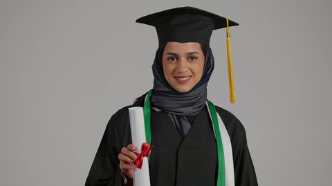 حفل تخرج، بنت سعودية تحتفل بإنهاء الدراسة الجامعية، بورترية مقرب لطالبة عربية خليجية اماراتية ترتدي ملابس التخرج وتمسك بيدها شهادة النجاح والتفوق، ايماءات وجه تدل على السعادة، خريجة جامعية، تلميذة متفوقة، مدارس وجامعات
