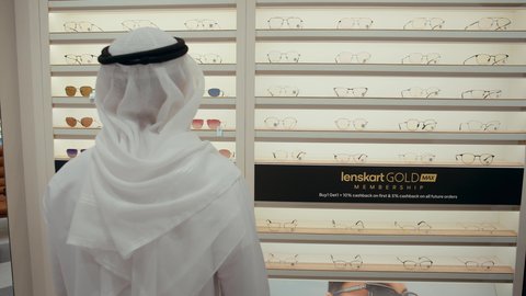سيده اماراتيه تقوم بمساعده الزبائن في اختيار المقاسات المناسبه لهم، رجل اماراتي يرتدي الكندوره والغتره البيضاء يقوم باختيار النظارة الطبيه المناسبة، الاهتمام بالمظهر الخارجي، التسوق وشراء النظارات الطبيه من المولات، مفهوم ضعف النظر