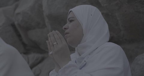 وقفة حجاج بيت الله الحرام على جبل عرفات في المملكة العربية السعودية, تصوير مقرب لحاجة تقوم بالدعاء والتوجه إلى الله الكريم في جبل الرحمة, الخشوع والمشاعر الإيمانية الإسلامية العظيمة, أداء فرائض الإسلام في مكة المكرمة، إتمام مناسك الحج