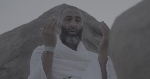 Completing the Hajj rituals, pilgrims standing on Mount Arafat in the Kingdom of Saudi Arabia, a close-up of a pilgrim praying and turning to God Almighty on Mount Arafat, humility and great Islamic feelings of faith, performing the Islamic duties in Mecca.