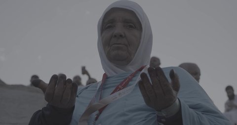 وقفة حجاج بيت الله الحرام على جبل عرفات في المملكة العربية السعودية, تصوير مقرب لحاجة تقوم بالدعاء والتوجه إلى الله الكريم في جبل الرحمة, الخشوع والمشاعر الإيمانية الإسلامية العظيمة, أداء فرائض الإسلام في مكة المكرمة، إتمام مناسك الحج