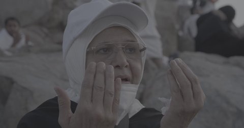 وقفة حجاج بيت الله الحرام على جبل عرفات في المملكة العربية السعودية, تصوير مقرب لحاجة تقوم بالدعاء والتوجه إلى الله الكريم في جبل الرحمة, الخشوع والمشاعر الإيمانية الإسلامية العظيمة, أداء فرائض الإسلام في مكة المكرمة، إتمام مناسك الحج