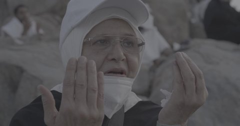 Pilgrims stand on Mount Arafat in the Kingdom of Saudi Arabia. A close-up of a pilgrim praying and turning to God Almighty on Mount Arafat. Reverence and the great feelings of Islamic faith. Performing the duties of Islam in Mecca. Completing the Hajj rituals.