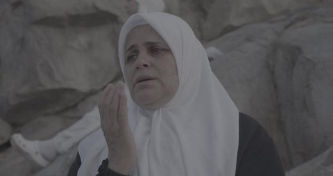 Pilgrims stand on Mount Arafat in the Kingdom of Saudi Arabia. A close-up of a pilgrim praying and turning to God Almighty on Mount Arafat. Reverence and the great feelings of Islamic faith. Performing the duties of Islam in Mecca. Completing the Hajj rituals.