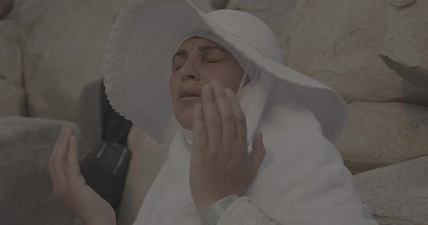 وقفة حجاج بيت الله الحرام على جبل عرفات في المملكة العربية السعودية, تصوير مقرب لحاجة تقوم بالدعاء والتوجه إلى الله الكريم في جبل الرحمة, الخشوع والمشاعر الإيمانية الإسلامية العظيمة, أداء فرائض الإسلام في مكة المكرمة، إتمام مناسك الحج