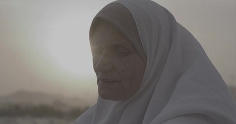 وقفة حجاج بيت الله الحرام على جبل عرفات في المملكة العربية السعودية, تصوير مقرب لحاجة تقوم بالدعاء والتوجه إلى الله الكريم في جبل الرحمة, الخشوع والمشاعر الإيمانية الإسلامية العظيمة, أداء فرائض الإسلام في مكة المكرمة، إتمام مناسك الحج