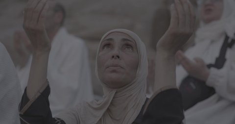 وقفة حجاج بيت الله الحرام على جبل عرفات في المملكة العربية السعودية, تصوير مقرب لحاجة تقوم بالدعاء والتوجه إلى الله الكريم في جبل الرحمة, الخشوع والمشاعر الإيمانية الإسلامية العظيمة, أداء فرائض الإسلام في مكة المكرمة، إتمام مناسك الحج