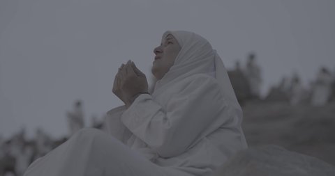 Pilgrims stand on Mount Arafat in the Kingdom of Saudi Arabia. A close-up of a pilgrim praying and turning to God Almighty on Mount Arafat. Reverence and the great feelings of Islamic faith. Performing the duties of Islam in Mecca. Completing the Hajj rituals.  Pilgrim, man, close-up
