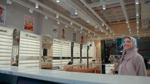 Choosing new glasses, buying sun glasses, two Emirati Gulf Arab friends shopping and buying new sunglasses, the concept of shopping and purchasing from the mall