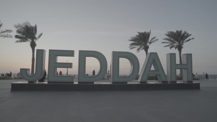 A model of the word Jeddah in English on the waterfront, Jeddah Corniche in the Kingdom of Saudi Arabia, interest in planting palm trees in coastal cities, the concept of tourism in Saudi Arabia
