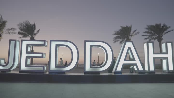 A model of the word Jeddah in English on the waterfront, Jeddah Corniche in the Kingdom of Saudi Arabia, interest in planting palm trees in coastal cities, the concept of tourism in Saudi Arabia