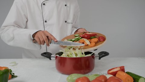 Skills in presenting and decorating food in unique and innovative ways, professionalism in the profession of a chef, the pleasure of preparing delicious recipes, a close-up of the hand of a young Arab Gulf Emirati man wearing a special chef's uniform and preparing healthy food