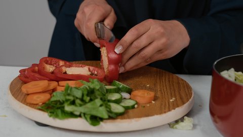 تجهيز مكونات السلطات والاطباق الصحية، تعلم وتطبيق فنون الطهي ،تصوير مقرب لامراة عربية خليجية اماراتية ترتدي العباءة الكحلي تقوم يتقطيع الفلفل الملون،سيده سعودية تقوم بقضاء أوقات ممتعه  في المطبخ