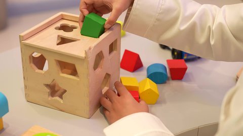 رياض أطفال عربية عمانيه تختص بالاعتناء بالأطفال، أداء الكثير من الأنشطة الممتعة، طفل عماني في رياض الأطفال والحاضنات، تصوير مقرب لايدي طفل عربي خليجي سعودي يقوم بمحاوله ادخال القطع في مكانها الصحيح