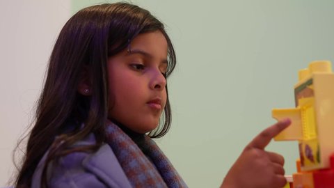 التسلية والترفيه ومتعه الانشطة الترفيهية،  بنت عربية خليجية سعودية تقضي اوقات ممتعة باللعب، عطلة صيفية سعيدة، قضاء اوقات ممتعة، طفله عربيه عمانيه ترتدي الزي الكاجوال تلعب بالبزل، الاهتمام بالاطفال في رياض الاطفال