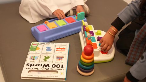 مهارات وأنشطة تساعد على التطور الفكري، الجلسات والحصص الإبداعية في الروضات السعوديه، إيماءات وجه تدل على السعادة والمتعة والتركيز، اطفال يستمتعون بالعاب الذكاء في المدرسه، طفل عربي خليجى سعودي برفقه صديقته، اللعب سويا في المدرسه، لعبه برج هانوي