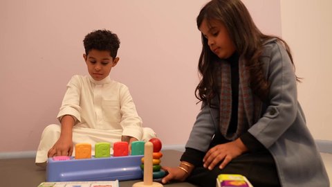 إيماءات وجه تدل على السعادة والمتعة والتركيز، لعبه برج هانوي ، مهارات وأنشطة تساعد على التطور الفكري، الجلسات والحصص الإبداعية في الروضات السعودية، اطفال عرب سعوديون يستمتعون بالعاب الذكاء في المدرسه، طفل عربي خليجى عماني برفقه صديقته