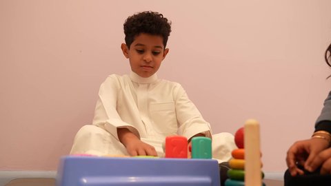 لعبه برج هانوي ، مهارات وأنشطة تساعد على التطور الفكري، الجلسات والحصص الإبداعية في الروضات السعودية، إيماءات وجه تدل على السعادة والمتعة والتركيز، اطفال عرب سعوديون يستمتعون بالعاب الذكاء في المدرسه، طفل عربي خليجى عماني برفقه صديقته