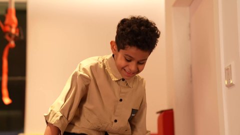 ايماءات الفرح والسرور، ولد عماني يرتدي الزي الكاجوال يقوم باللعب في المدرسه، تعليم وابداع و تنمية المهارات، الاهتمام بالاطفال في الروضة، طفل يقوم بالتسلية والترفيه