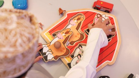 دعم ذوي الهمم والاهتمام بهم، ولد عربي عماني يرتدي الدشداشه والكمه من ذوي الهمم يقوم بانشطه ذهنيه والعاب الذكاء، اطفال ذوي الاحتياجات الخاصة والاهتمام بهم