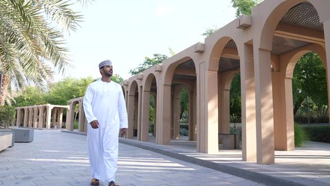الخروج إلى أحد الاماكن العامة للترفيه عن النفس،  الاستجمام بالطبيعة واستنشاق الهواء الطلق،الاستمتاع بالأجواء في إحدى المنتزهات، رجل عربي خليجي عماني يرتدي الزي العماني يسير فى احدي حدائق سلطنة عمان
