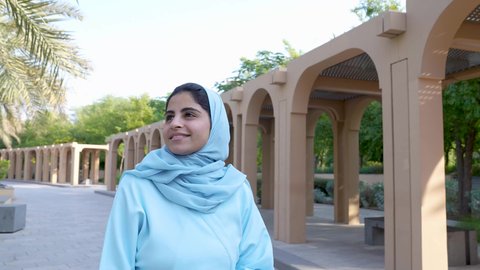 الخروج إلى أحد الاماكن العامة للترفيه عن النفس ، الاستجمام بالطبيعة واستنشاق الهواء الطلق، تصوير لسيدة عربية خليجية عمانية ترتدي الزي العماني يسير فى احدي حدائق سلطنة عمان ، الاستمتاع بالأجواء في إحدى المنتزهات