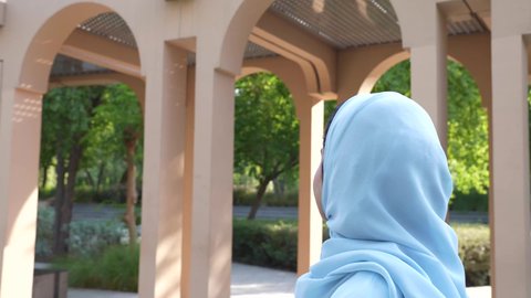 الاستمتاع بالأجواء في إحدى المنتزهات، الاستجمام بالطبيعة واستنشاق الهواء الطلق، تصوير لسيدة عربية خليجية عمانية ترتدي الزي العماني يسير فى احدي حدائق سلطنة عمان ،الخروج إلى أحد الاماكن العامة للترفيه عن النفس