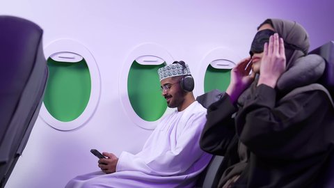 قضاء العطلة الصيفية في السفر والسياحه, مفهوم النوم والراحه في الرحلة السياحية ، تصوير مقرب من الجانب لامرأة عربية عمانيه خليجية نائمه على كرسيها في الطائرة، الشعور بالتعب والارهاق والحاجة الى النوم والراحة، خطوط الطيران العماني