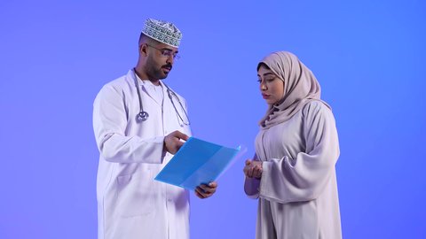 مهن ووظائف طبية ، مراجعة ملف وتشخيص حالة المرضى ، تصوير لمرأة عربية خليجية عمانيه مع الطبيب ، موعد مع الطبيب لمراجعة الحالة وتلقي الإستشارات والتعليمات الطبية ، مفهوم الطب والرعاية الصحية ، تقديم الرعاية والخدمات الصحية
