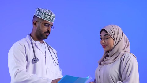 مراجعة ملف وتشخيص حالة المرضى ، مهن ووظائف طبية ، تصوير لمرأة عربية خليجية عمانيه مع الطبيب ، موعد مع الطبيب لمراجعة الحالة وتلقي الإستشارات والتعليمات الطبية ، مفهوم الطب والرعاية الصحية ، تقديم الرعاية والخدمات الصحية