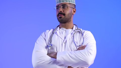 العمل في القطاع الصحي لتقديم الخدمات الصحية ، تصوير لطبيب عربي خليجي عماني بإيدي متقاطعة ، ينظر إلى الكاميرا ، يقدم خدماته للمرضى بكل كفاءه ، مفهوم الطب والرعاية الصحية ، مهن ووظائف طبية