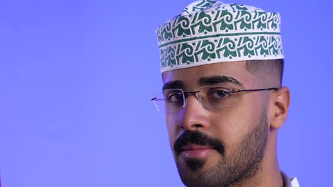 المشاركة بالاعياد والمناسبات الوطنية، الفخر والاعتزاز بالانتماء للهوية، الاحتفال بذكرى اليوم الوطني العماني، الاعتزاز والفخر بالرموز والراية العمانية، تصوير لطبيب عربي خليجي عماني تنظر الى علم عمان، مفهوم حب الوطن