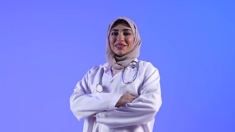 العمل في القطاع الصحي لتقديم الخدمات الصحية، تصوير لطبيبه عربيه عمانيه خليجيه بإيدي متقاطعة ، ينظر إلى الكاميرا ، يقدم خدماته للمرضى بكل كفاءه ، مفهوم الطب والرعاية الصحية ، مهن ووظائف طبية