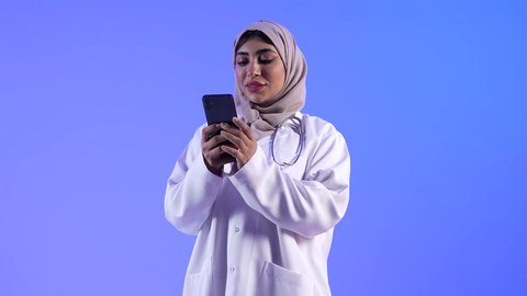 تقديم الرعاية والخدمات الصحية ، مهن ووظائف طبية ، مفهوم الطب والرعاية الصحية ، الفحص الطبي للأطفال ، مفهوم إستخدام التكنولوجيا وأجهزة تقنية حديثة ، تصوير لطبيبة خليجية عمانيه تستخدم جهاز الهاتف المحمول