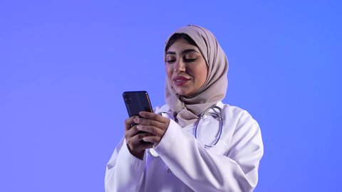 مفهوم الطب والرعاية الصحية ، الفحص الطبي للأطفال ، مفهوم إستخدام التكنولوجيا وأجهزة تقنية حديثة ، تصوير لطبيبة خليجية عمانيه تستخدم جهاز الهاتف المحمول، تقديم الرعاية والخدمات الصحية ، مهن ووظائف طبية