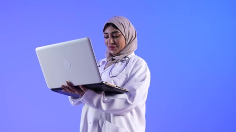 مفهوم إستخدام التكنولوجيا وأجهزة تقنية حديثة ، تصوير لطبيبة خليجية عمانيه تستخدم جهاز الحاسوب المحمول، مفهوم الطب والرعاية الصحية ، الفحص الطبي للأطفال ، تقديم الرعاية والخدمات الصحية ، مهن ووظائف طبية