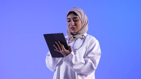 تصوير لطبيبة خليجية عمانيه تستخدم جهاز التابلت، تقديم الرعاية والخدمات الصحية ، مهن ووظائف طبية ، مفهوم الطب والرعاية الصحية ، الفحص الطبي للأطفال ، مفهوم إستخدام التكنولوجيا وأجهزة تقنية حديثة