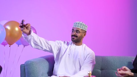 توثيق اللحظات التذكاريه فى العيد ، تبادل المعايدات, تقديم الضيافة العربية والحلويات الشعبية، تجمع العائلة العمانية لاستقبال العيد المبارك, مفهوم الحنان والمحبة والمودة، إظهار مشاعر الفرح والسعادة بقدوم العيد، تقديم التمر السعودي ، تصوير لعائلة عربية خليجية عمانية تجلس في غرفة المعيشة بايماءات السعادة