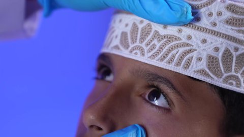 الفحص الطبي للأطفال ، الرعاية الطبية للأطفال ،تصوير لأم عربية خليجية عمانيه مع طفلها  في زيارة الى دكتور الأطفال ، موعد مع الطبيب لتلقي العلاج ، مستشفى خاص بالأطفال ، مفهوم الطب والرعاية الصحية ، يستمع الطبيب لقلب الطفل عبر سماعة الأذن